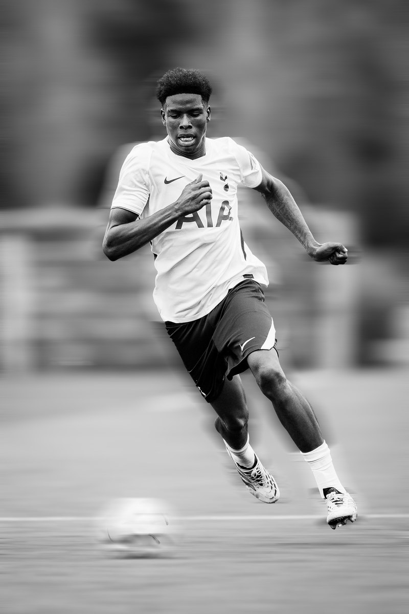 Tottenham player running at pace, black and white, motion blur edit